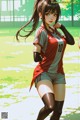 A woman in a soccer uniform is standing on a field.