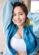 A woman in a white top and blue shirt posing for a picture.